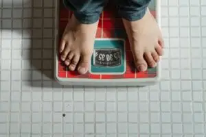 are mushrooms good for weight loss. mushrooms. weight loss From above crop anonymous barefoot child in jeans standing on weigh scales on tiled floor of bathroom